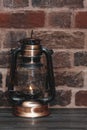 Kerosene lamp with a burning flame on a wooden table Royalty Free Stock Photo