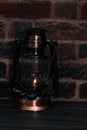 Kerosene lamp with a burning flame on a wooden table Royalty Free Stock Photo