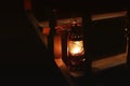 Kerosene lamp in the dark. The lamp on the wooden stairs