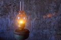 Kerosene lamp burning on a gray wall background Royalty Free Stock Photo