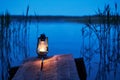 A kerosene lamp on the shore of a forest lake illuminates the silence of a summer night with a magical light