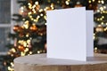 Standing empty square greeting card mock up in front of a christmas tree