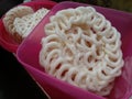 Kerupuk or crackers are placed in a pink container. One of the snacks in Indonesia.