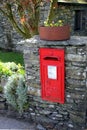 Keswick, Cumbria, UK - April 6th 2019: Old vintage British Georgian letter box, mounted into a dry stone wall in the English Lake
