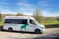 Keswick, Cumbria, UK - April 6th 2019: White minibus van belonging to Mountain Goat Tours, operating in the Lake District in