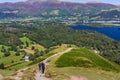 Hikers climbing the hill at Catbells overlooking Derwentwater and the town of Keswick in the