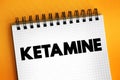 Ketamine is a dissociative anesthetic used medically for induction and maintenance of anesthesia, text concept on notepad