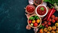 Ketchup sauce in a bowl. Cherry tomatoes, spices, chili peppers, olive oil, parsley. Top view. On a stone background. Royalty Free Stock Photo