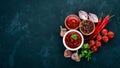 Ketchup sauce in a bowl. Cherry tomatoes, spices, chili peppers, olive oil, parsley. Top view. On a stone background. Royalty Free Stock Photo