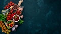 Ketchup sauce in a bowl. Cherry tomatoes, spices, chili peppers, olive oil, parsley. Top view. On a stone background. Royalty Free Stock Photo