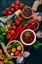 Ketchup sauce in a bowl. Cherry tomatoes, spices, chili peppers, olive oil, parsley. Top view. On a stone background. Royalty Free Stock Photo