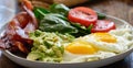 Keto breakfast plate with eggs bacon and mashed avocado Royalty Free Stock Photo