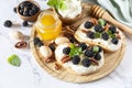 Keto diet sandwiches, snack. Sweet bruschetta with cheese and berries blackberry ricotta and honey on marble table. Healthy