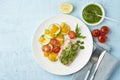 Keto dinner with white fish. Oven baked fillet of cod, pike perch with vegetables and pesto sauce Royalty Free Stock Photo