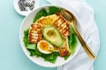 keto ketogenic diet soft boiled eggs with avocado and lettuce on pastel background closeup top view