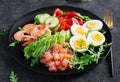 Ketogenic diet breakfast. Salt salmon salad with boiled shrimps, prawns, tomatoes, spinach, eggs and avocado. Royalty Free Stock Photo