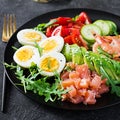 Ketogenic diet breakfast. Salt salmon salad with boiled shrimps, prawns, tomatoes, spinach, eggs and avocado. Royalty Free Stock Photo