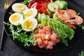 Ketogenic diet breakfast. Salt salmon salad with boiled shrimps, prawns, tomatoes, spinach, eggs and avocado. Royalty Free Stock Photo