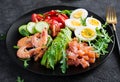 Ketogenic diet breakfast. Salt salmon salad with boiled shrimps, prawns, tomatoes, spinach, eggs and avocado. Royalty Free Stock Photo