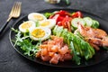 Ketogenic diet breakfast. Salt salmon salad with boiled shrimps, prawns, tomatoes, spinach, eggs and avocado. Royalty Free Stock Photo