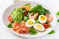 Ketogenic diet breakfast. Salt salmon salad with boiled shrimps, prawns, tomatoes, spinach, eggs and avocado. Royalty Free Stock Photo