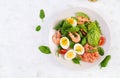 Ketogenic diet breakfast. Salt salmon salad with boiled shrimps, prawns, tomatoes, spinach, eggs and avocado. Royalty Free Stock Photo