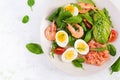 Ketogenic diet breakfast. Salt salmon salad with boiled shrimps, prawns, tomatoes, spinach, eggs and avocado. Royalty Free Stock Photo