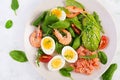 Ketogenic diet breakfast. Salt salmon salad with boiled shrimps, prawns, tomatoes, spinach, eggs and avocado. Royalty Free Stock Photo