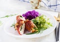Dinner dish with chicken meat roll wish bacon and salad wich red cabbage, cucumber, arugula. Royalty Free Stock Photo