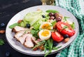 Ketogenic diet. Keto brunch. Boiled egg, pork steak and olives, cucumber, spinach, brie cheese, nuts and tomato Royalty Free Stock Photo