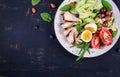 Ketogenic diet. Boiled egg, pork steak and olives, cucumber, spinach, brie cheese, nuts and tomato. Top view Royalty Free Stock Photo