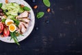 Ketogenic diet. Boiled egg, pork steak and olives, cucumber, spinach, brie cheese, nuts and tomato. Top view Royalty Free Stock Photo