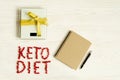 Ketogenic diet notes in the notebook on natural wood table. Concept of Ketogenic diet with scale and messure tape