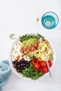 Ketogenic lunch bowl: spiralized courgette with avocado, tomato, feta cheese, olives, bacon