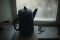 Kettle on background of window. Kettle with handle. Silhouette of kitchen utensils