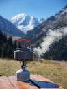 A kettle boils on a tourist gas burner in the mountains Royalty Free Stock Photo
