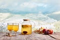 Kettle of delicious and healthy tea with lemons, oranges and fruits on snowy mountain background Royalty Free Stock Photo