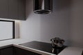 A kettle on the Electric stove on the kitchen counter with a kitchen hood in a modern kitchen