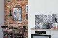 Electric stove in trendy kitchen with brick wall in dining room
