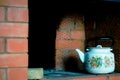 Kettle in the Russian old red brick oven. Royalty Free Stock Photo