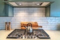 Kettle on top of a cooktop fixed on the countertop inside the kitchen of house