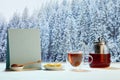 Kettle and two cups of delicious black tea with honey and lemons on winter forest background Royalty Free Stock Photo