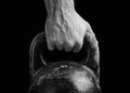 Close-up of a muscular hand holding a kettlebell