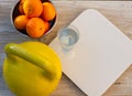 Kettlebell, tangerines, scales and glass of water on a wooden table Royalty Free Stock Photo