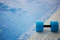 The kettlebell for water aerobics lies on the edge of the pool. Near the water.Exercise, swimming and a healthy Royalty Free Stock Photo