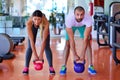 Kettlebells swing exercise man and woman workout at gym