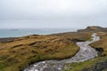 Ketubjorg bird cliffs with creek infront as leading lines towards the ocean during rainy weather.