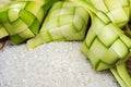 Ketupat casing and rice in bamboo container.