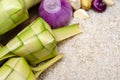 Ketupat casing and rice in bamboo container. Royalty Free Stock Photo