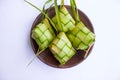 ketupat in earthenware plate isolated on white background. Ketupat Rice Dumpling is food served when idhul fitri eid mubarak. Royalty Free Stock Photo